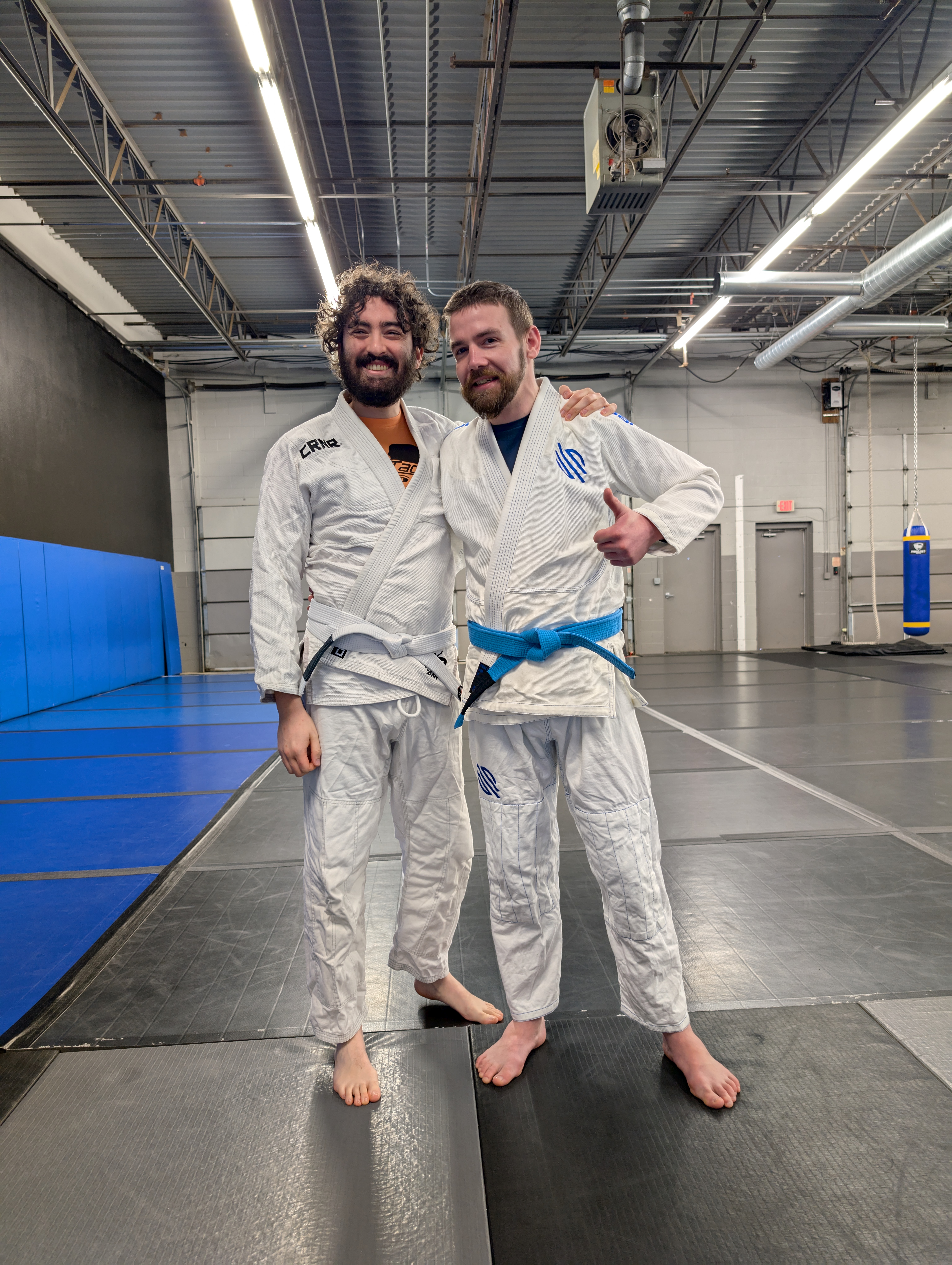 Two people wearing a gi and smiling at Tackle Jiu Jitsu