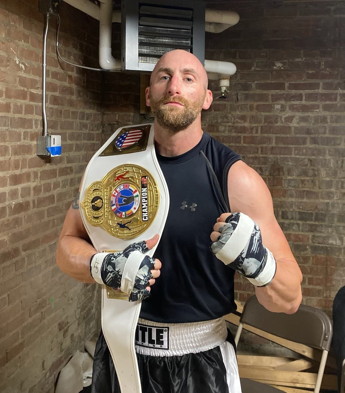 Kyle Horton holding a boxing belt that he won