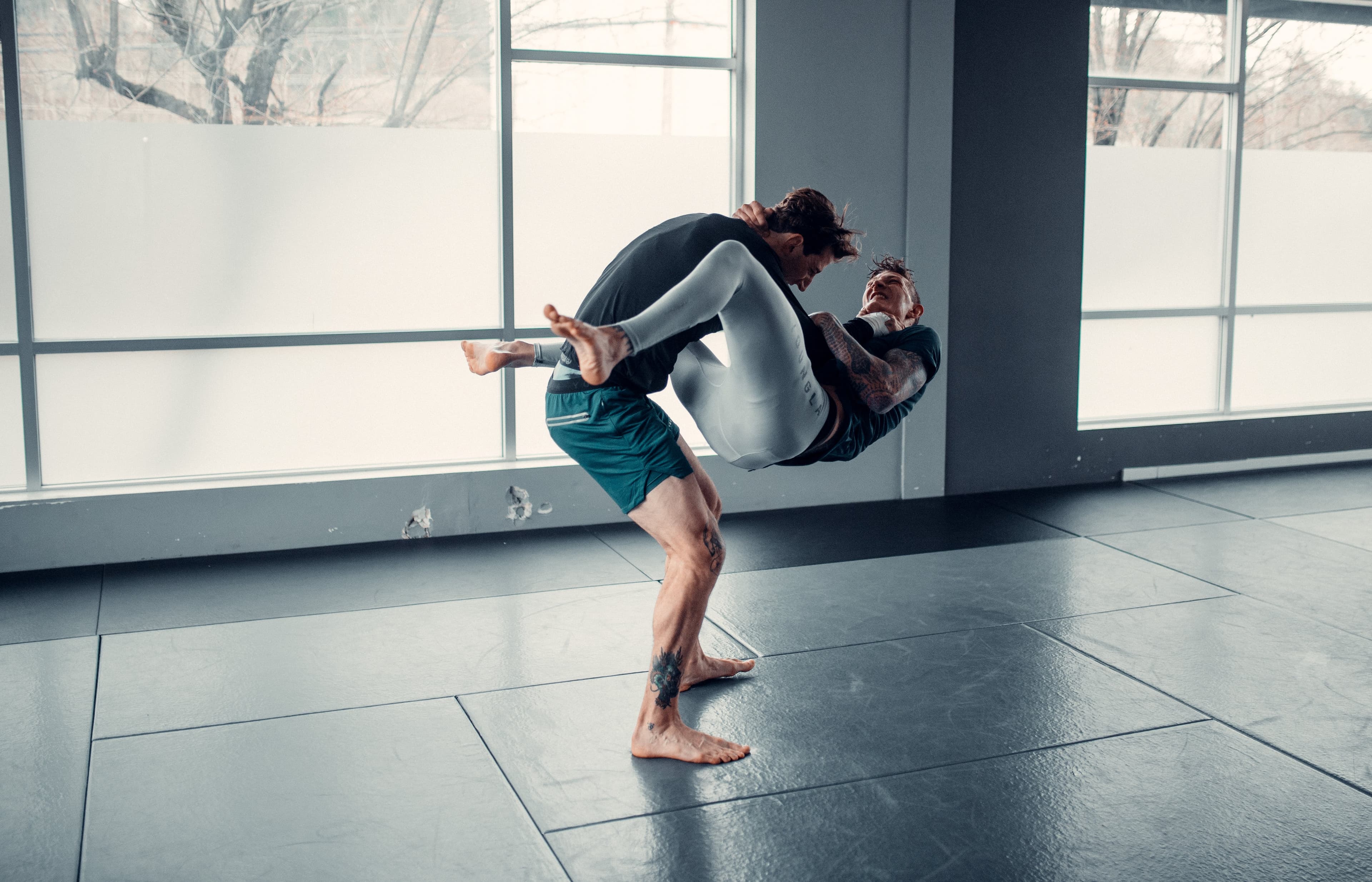 A man performing a flying armbar in no-gi jiu jitsu