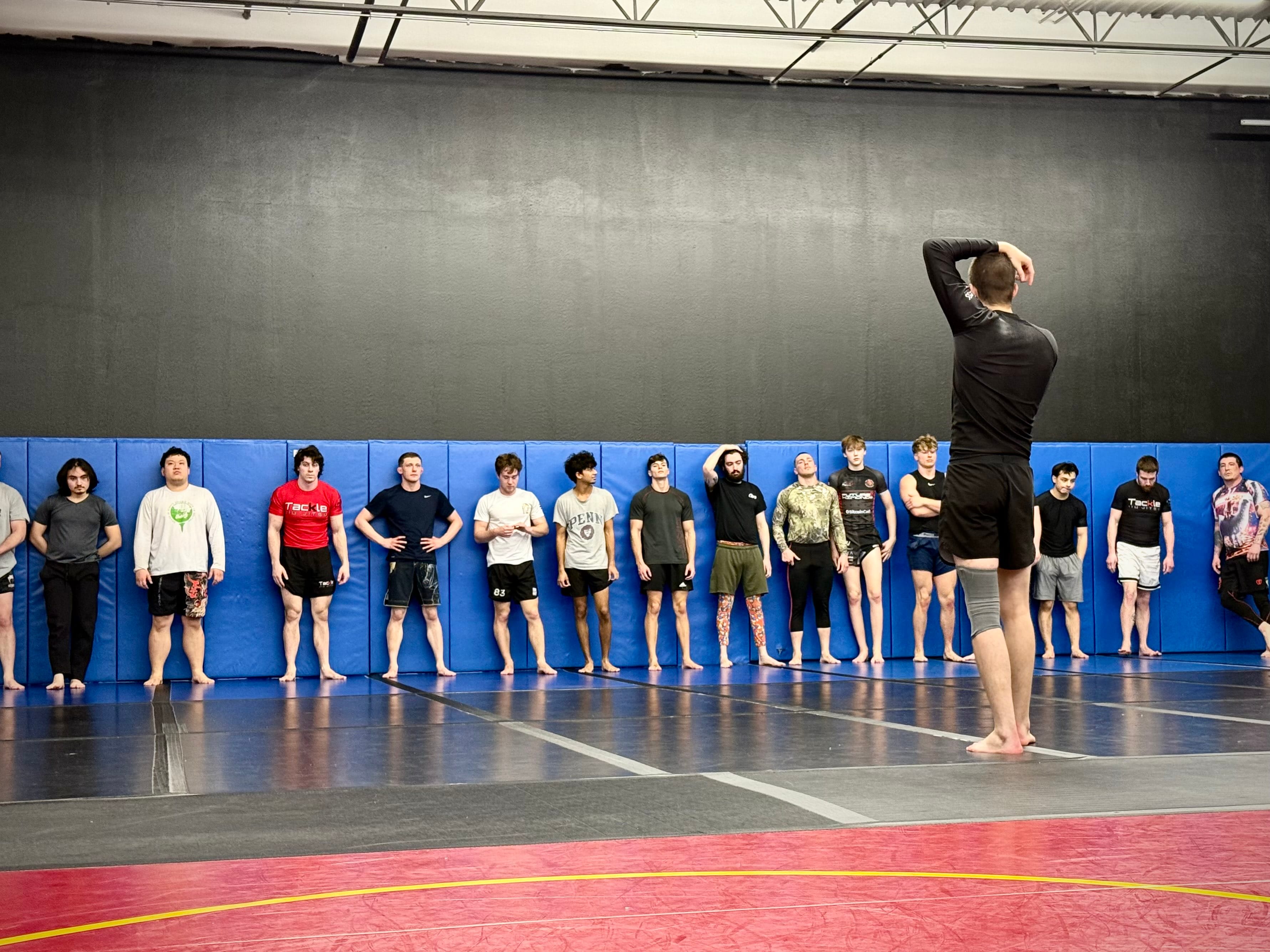 A jiu jitsu class lined up listening to a coach