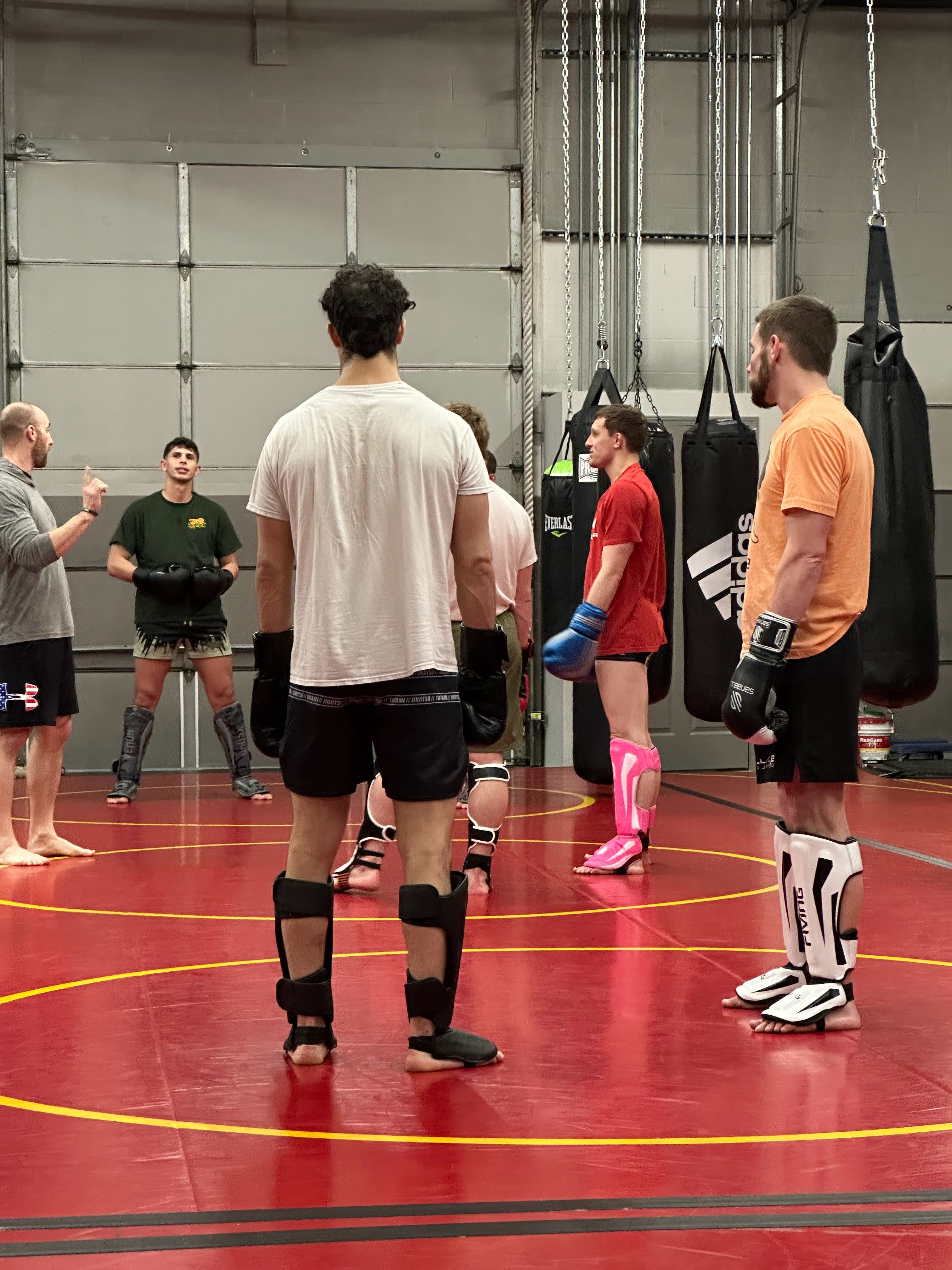 Kickboxing students standing and listening to a coach